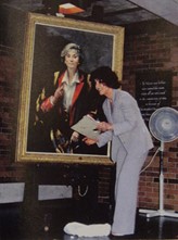 Brenda Bury is stood in front of a coloured portrait.