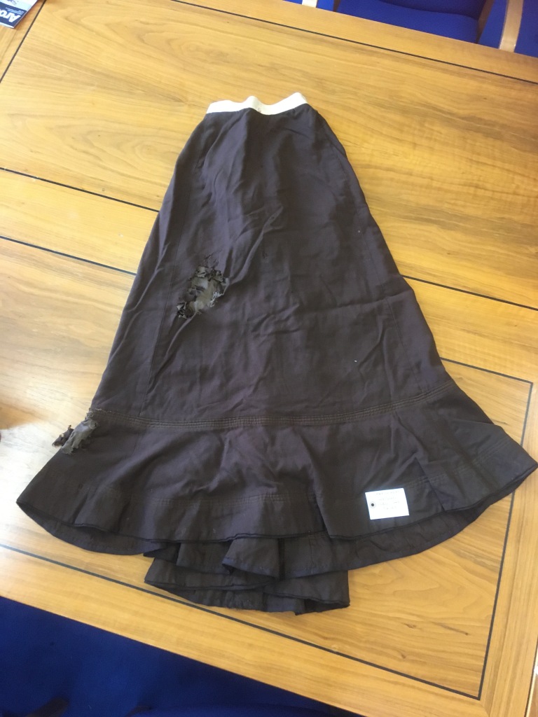 A ladies black skirt, in various places it has been damaged by moths